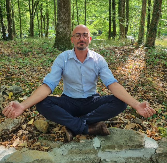 Quatre collègues en réunion autour d’un bureau, discutant devant des ordinateurs dans un espace de travail lumineux.